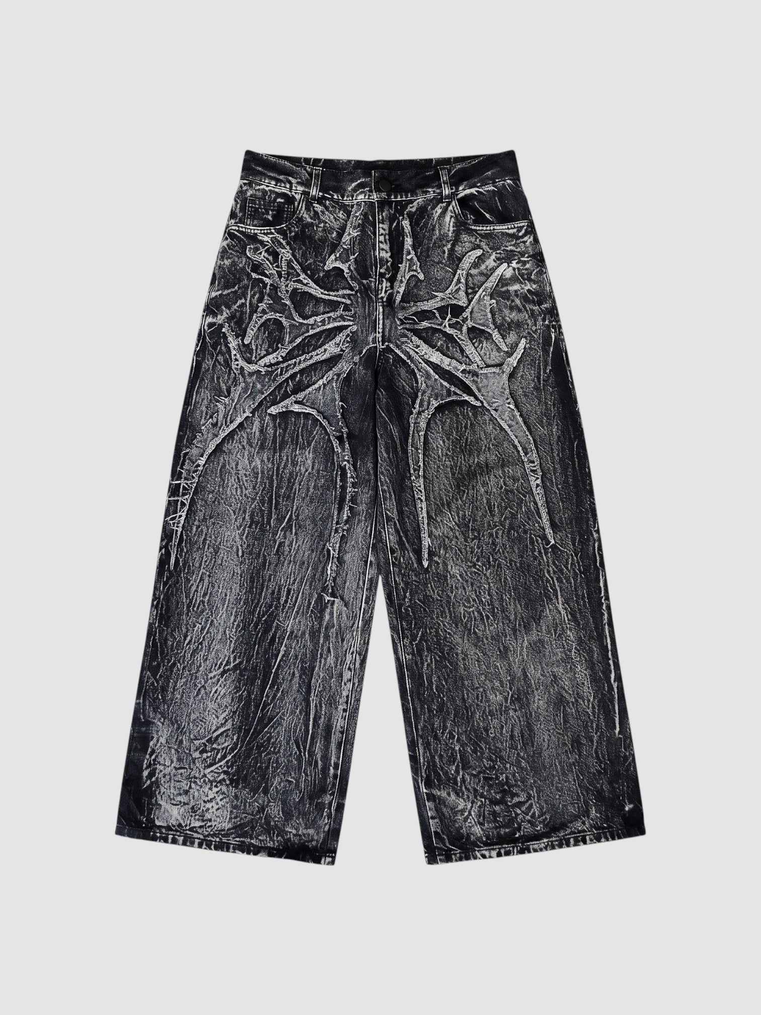 Y2K Studio wide-leg denim jeans in acid wash black and grey with raw-edge spiderweb fabric appliqués.