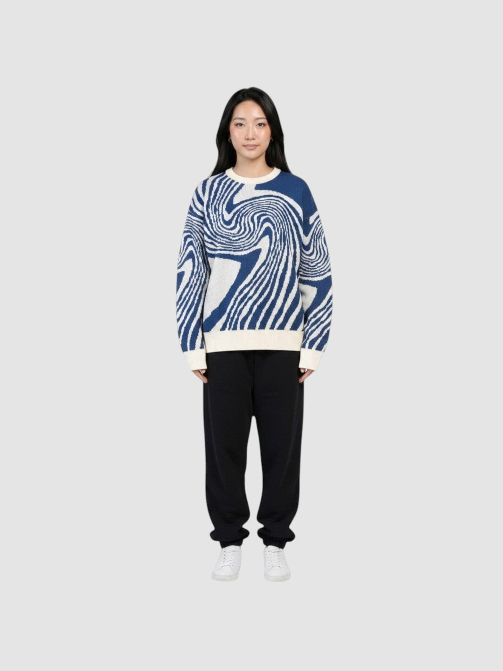 Y2K STUDIO model wearing a lightweight navy and off-white spiral pattern knit sweater with a round neck.