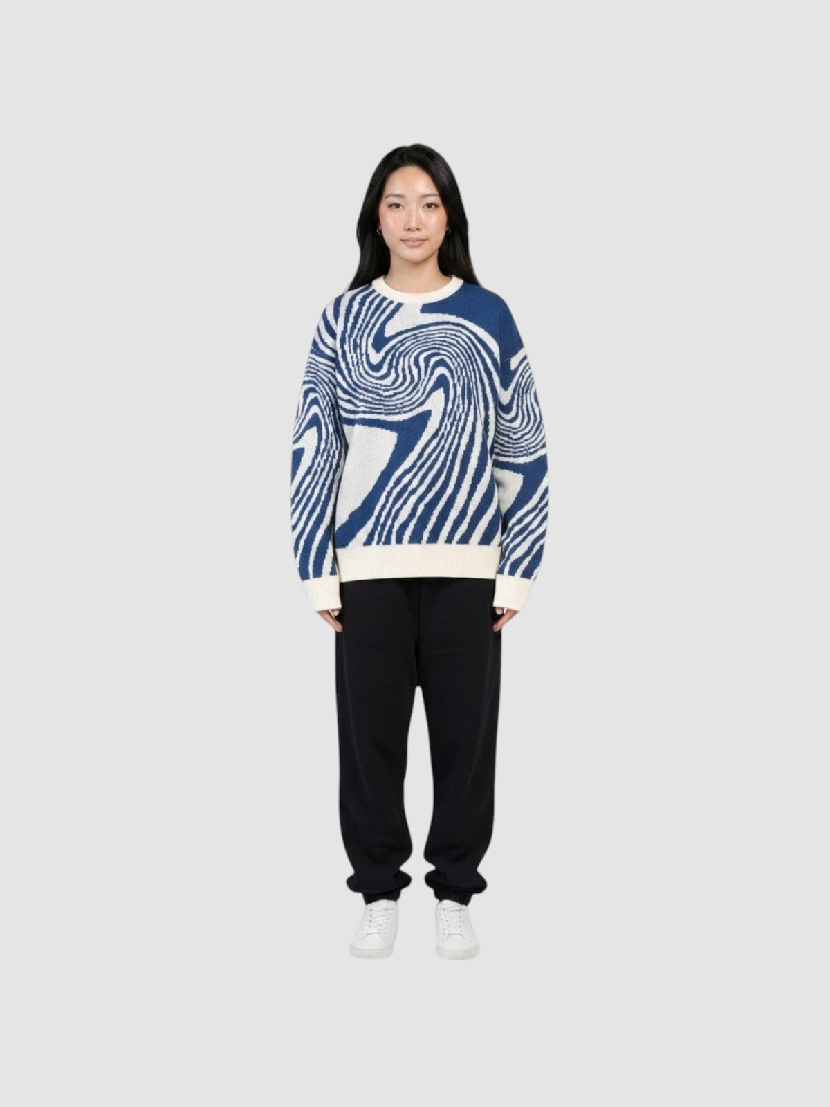 Y2K STUDIO model wearing a lightweight navy and off-white spiral pattern knit sweater with a round neck.
