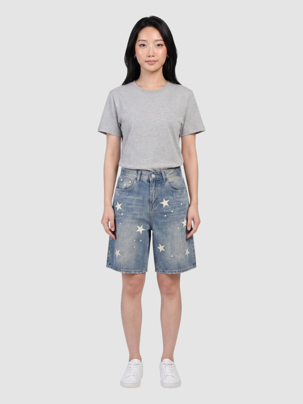 Y2K STUDIO high-waisted light blue denim jorts featuring scattered off-white star prints, worn by a model.