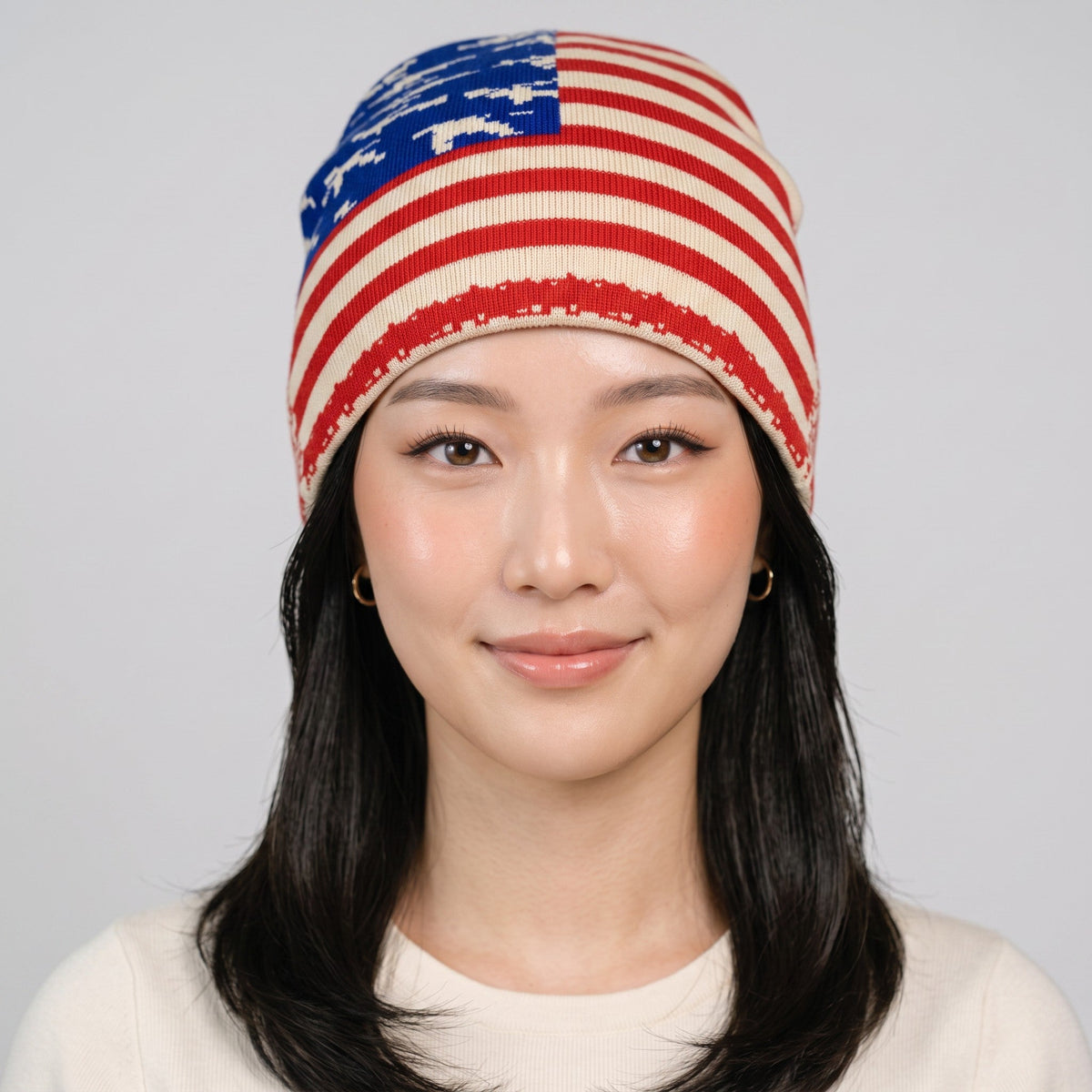 Y2K Studio USA flag beanie with stars and stripes pattern worn by a model on a light grey background