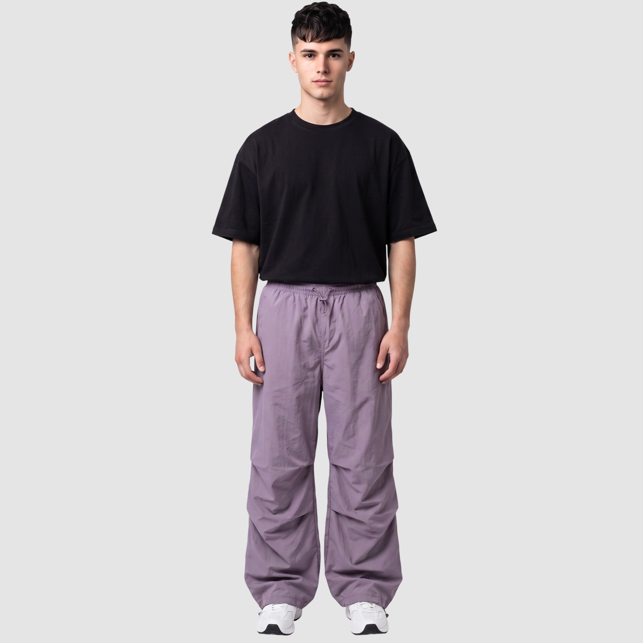 Y2K STUDIO model wearing a high-waisted matte violet parachute pant with gathered knees and adjustable drawstrings.