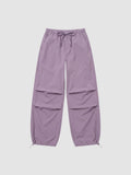 Y2K Studio high-waisted violet parachute pants in matte nylon with adjustable drawstring waist and ankle cuffs.