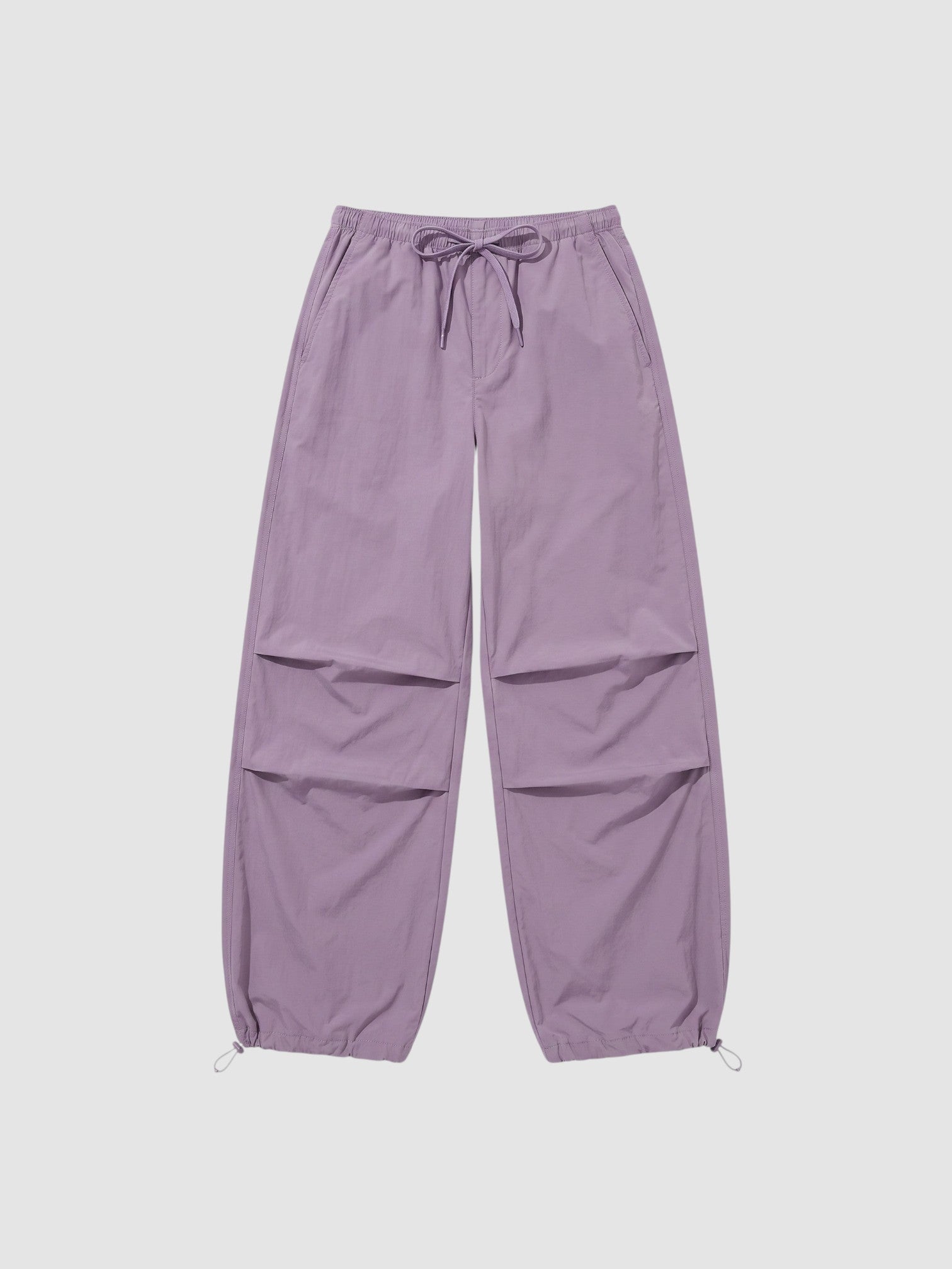 Y2K Studio high-waisted violet parachute pants in matte nylon with adjustable drawstring waist and ankle cuffs.