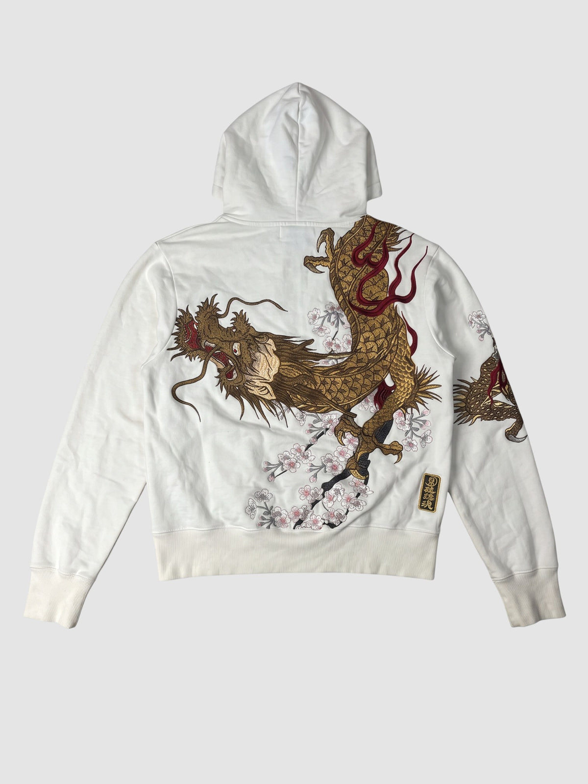 Y2K Studio white zip-up hoodie featuring a large golden dragon and cherry blossom graphic on the back