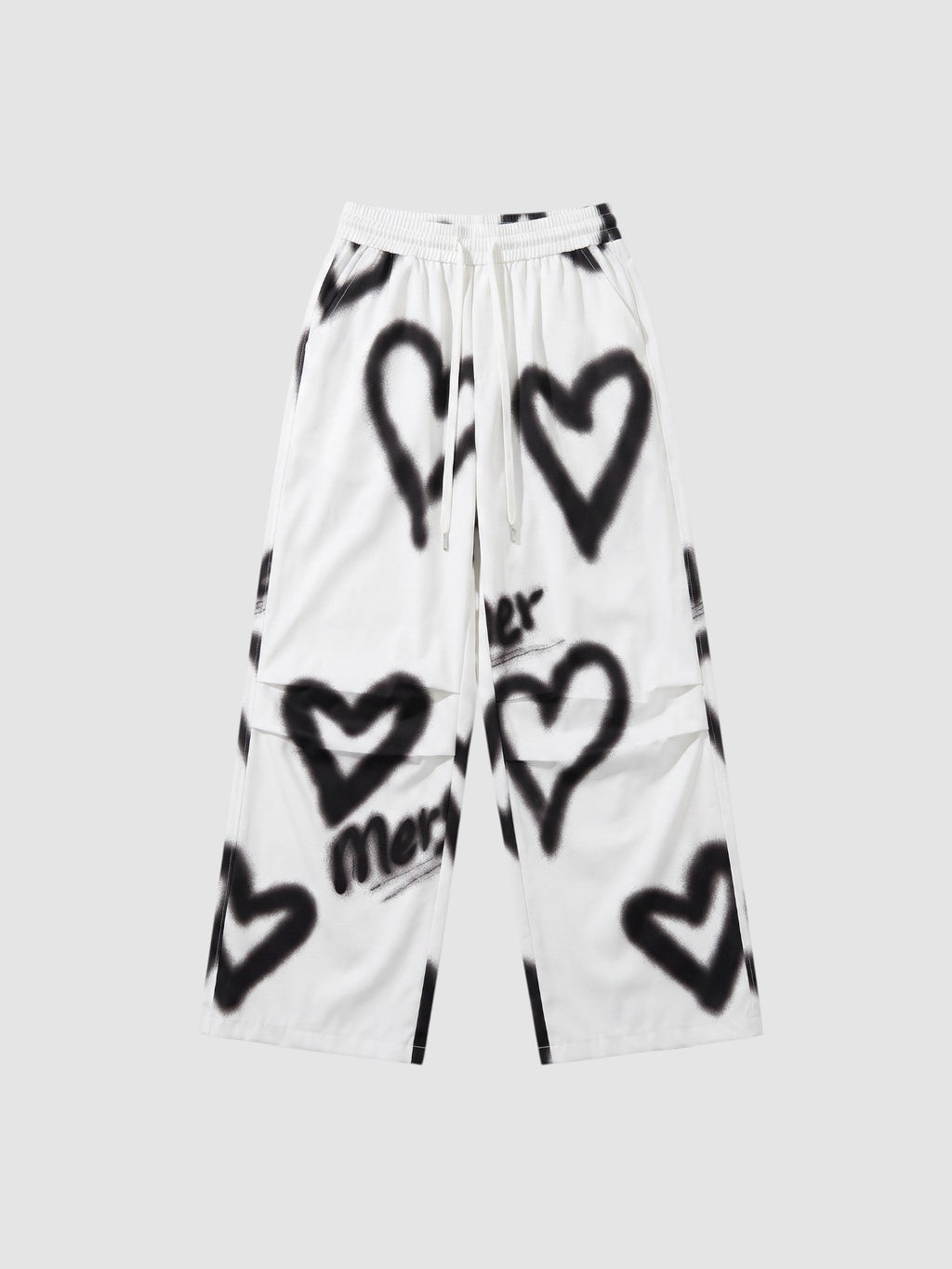 Y2K Studio white wide-leg pants featuring black spray-painted heart motifs and an elastic drawstring waist.