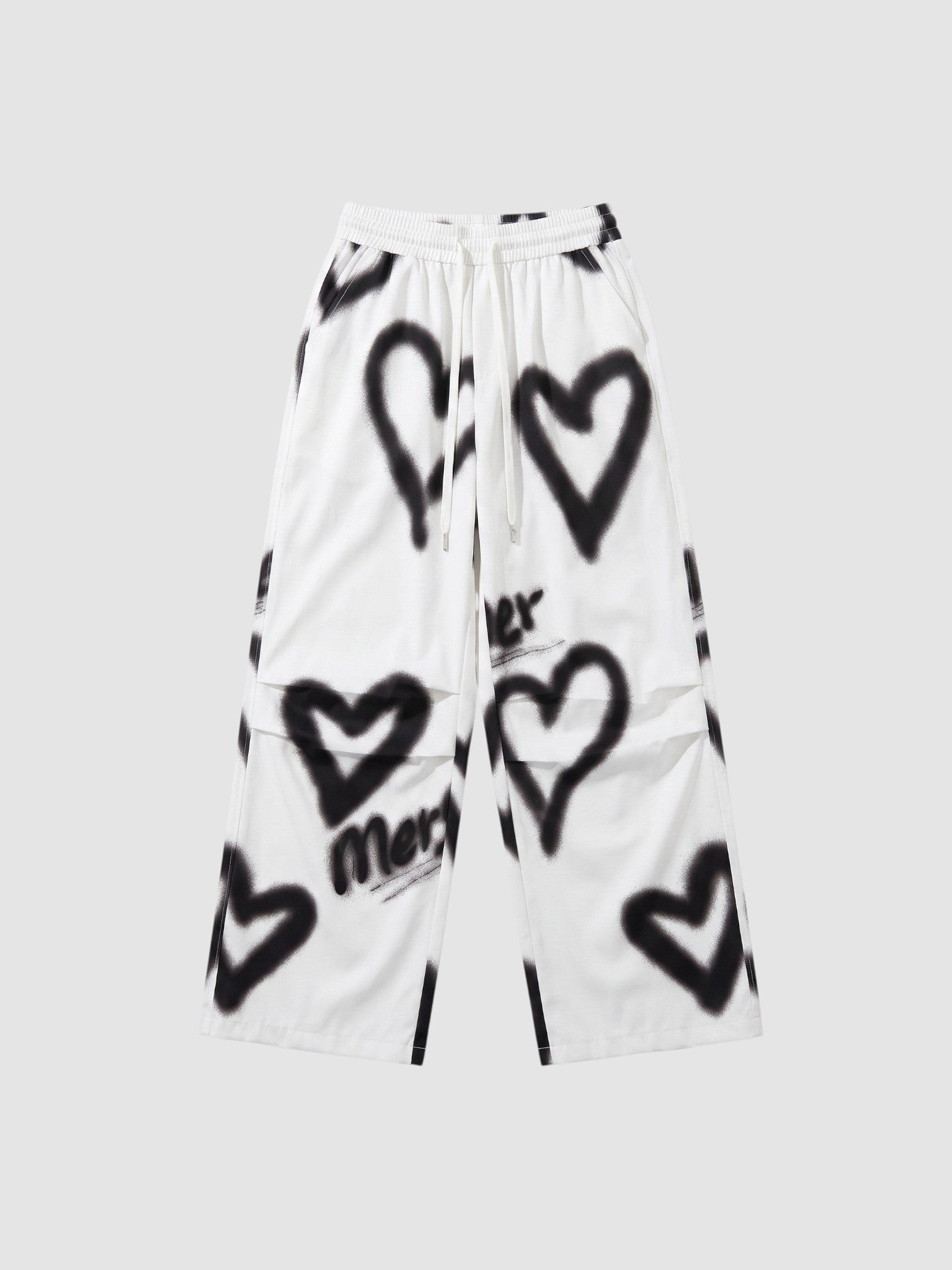 Y2K Studio white wide-leg pants featuring black spray-painted heart motifs and an elastic drawstring waist.