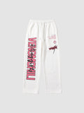 Y2K STUDIO white joggers featuring pink vertical lettering on the left leg and graphic prints on the right thigh.