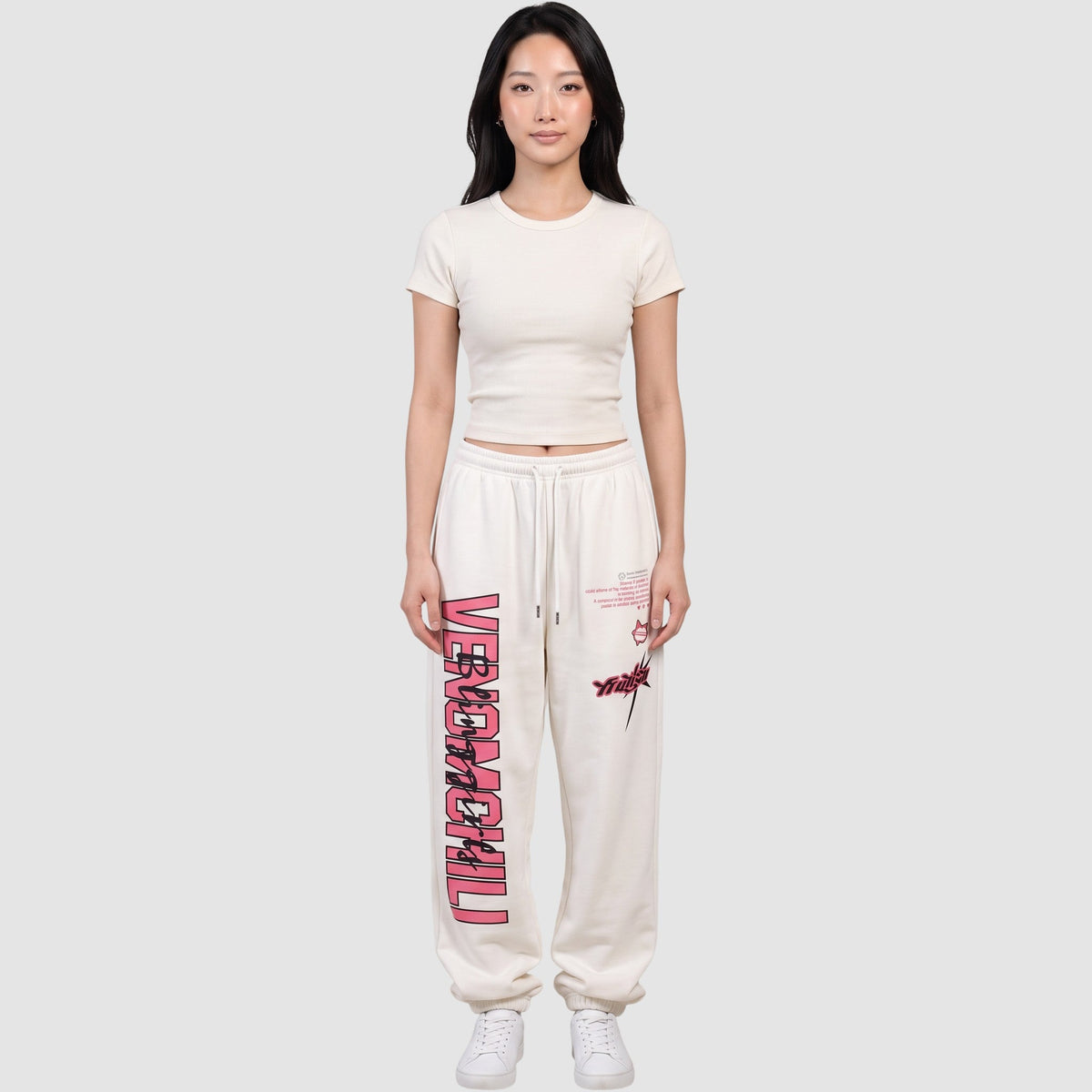 Y2K STUDIO white cotton blend joggers with pink vertical lettering and graphic prints worn by a model