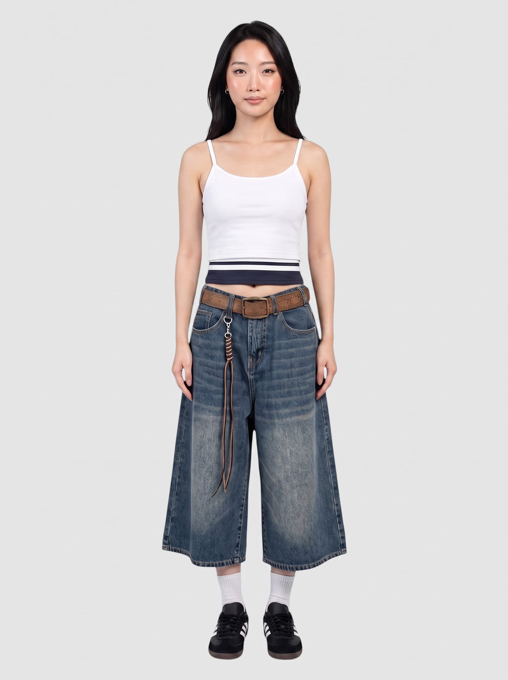 Y2K Studio model wearing wide-leg denim bermuda shorts with a faded wash, high waist, and brown leather belt.